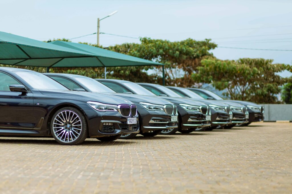 Row of luxury cars parked at an outdoor dealership, showcasing elegance.